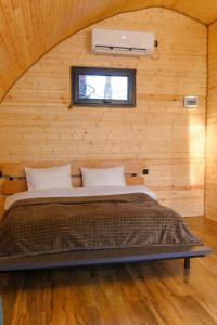a bedroom with a bed in a wooden wall at Cottage TKESHI in Godogani