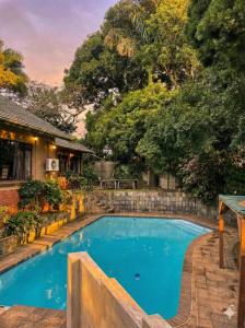 a swimming pool in the backyard of a house at Mtunzini Rustic Retreat in Mtunzini