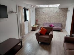 a living room with two couches and a tv at VISTALMONTE in Salento