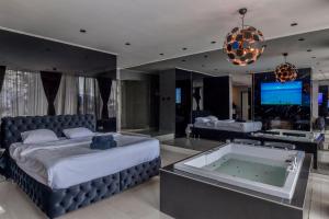 a bedroom with a large bed and a tub at Aura Villas Skopje in Skopje +51 photos