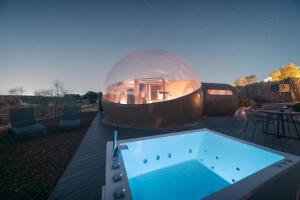 a glass dome house on a deck with a swimming pool at Miluna in Hormigos