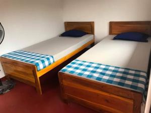 two twin beds in a room at 5th Dimension Academy rooms in Deniyaya