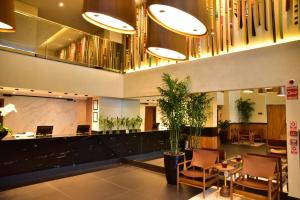 a lobby with a potted plant in a building at Hplus Premium Palmas in Palmas