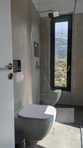 a bathroom with a toilet and a window at Villa Zina mit Infinity-Pool und Meerblick in Sitia +73 photos