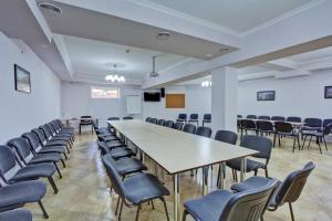 a conference room with a long table and chairs at Green Yard Hotel in Karakol