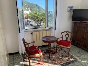 a room with two chairs and a table and a television at Il cuore di Moneglia - MONEGLIA APARTMENTS in Moneglia