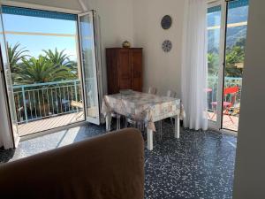a dining room with a table and a balcony at Il cuore di Moneglia - MONEGLIA APARTMENTS in Moneglia