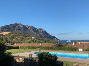 a resort with a swimming pool and a mountain at Villino Giò - Residence Abba Urci in Tertenìa