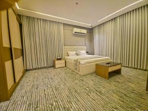 a hotel room with a bed and a table at النخبة الرفيعة للشقق المخدومة in Al Qurayyat
