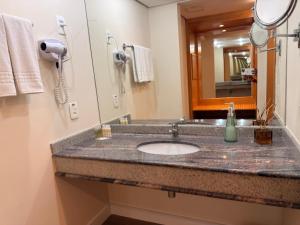 a bathroom with a sink and a mirror at Hotel & Residence Alphaville in Barueri +7 photos
