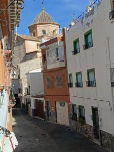 an alley with buildings and a tower in the background at Casa Lili in Vélez-Rubio