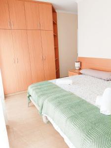 a bedroom with a bed with a green blanket on it at Casa Lili in Vélez-Rubio
