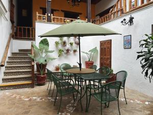 a table with chairs and an umbrella in a courtyard at Patio Guadalupe in San Cristóbal de Las Casas