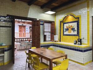 a restaurant with a wooden table and yellow chairs at Patio Guadalupe in San Cristóbal de Las Casas +36 photos