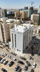 a large white building with cars parked in a parking lot at فندق روزز إس in Riyadh