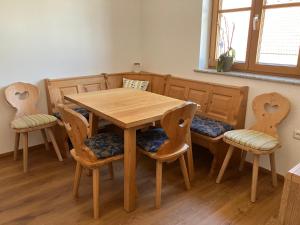 a wooden table and chairs in a room with a table at Bio-Ferienhof Hotz in Spital am Pyhrn