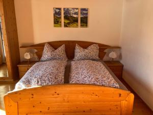 a bedroom with a wooden bed with two pillows at Bio-Ferienhof Hotz in Spital am Pyhrn