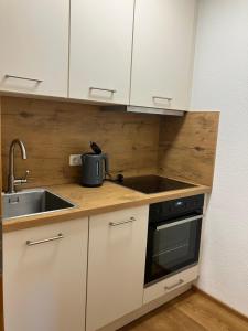a kitchen with white cabinets and a sink at Bio-Ferienhof Hotz in Spital am Pyhrn +9 photos
