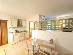 a kitchen with a table and chairs in a room at palazzo beddoro charming apartments in San Pantaleo
