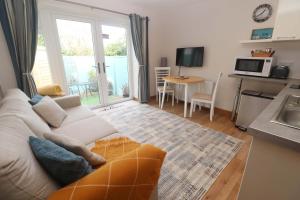 a living room with a white couch and a kitchen at Blake Lodge in Newquay