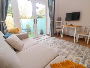 a living room with a white couch and a television at Blake Lodge in Newquay