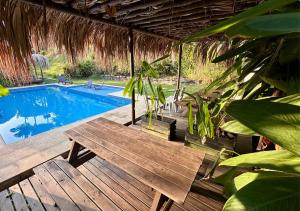 a wooden deck with a bench next to a swimming pool at Finca Hotel Tierra Verde in Girardota