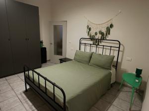 a bedroom with a bed and a green chair at Un mondo in pianura in Turano Lodigiano