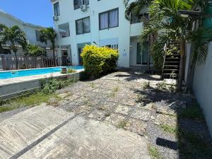 a building with a staircase next to a pool at Din villa in Cap Malheureux