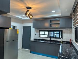 a kitchen with a refrigerator and a counter top at Happy Home in Trofwi