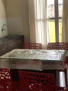 a kitchen with a table and chairs and a window at Zioneliteresidency in Kodaikānāl +4 photos