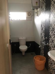 a small bathroom with a toilet and a sink at Zioneliteresidency in Kodaikānāl