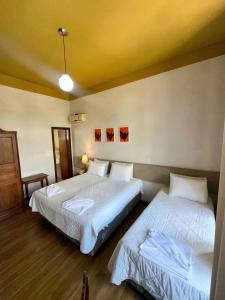 a room with two beds in a room at Hotel Lenheiros in São João del Rei