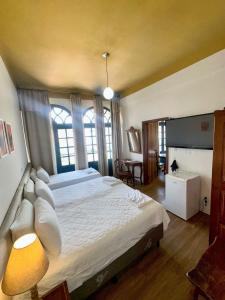 a large bedroom with a large bed and a window at Hotel Lenheiros in São João del Rei