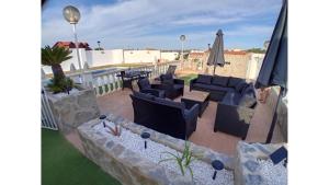 a patio with chairs and a table and an umbrella at Villa entre terre et mer in Montroy