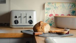 a loaf of bread on a cutting board next to a toaster at 2 Bridge View in Selby