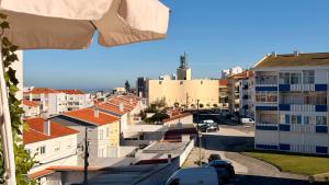 a view of a city with buildings and an umbrella at Refúgio na Praia de Santa Cruz- A poucos passos da praia, surf e restaurantes in Santa Cruz