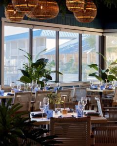 a restaurant with wooden tables and chairs and windows at SkyBeach Resort in St. Petersburg