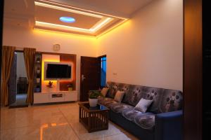 a living room with a couch and a tv at pathayil villa in Thekkady