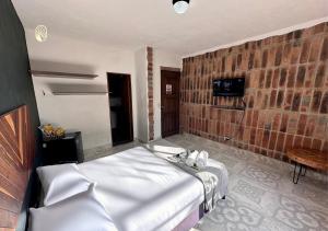 a bedroom with a bed and a brick wall at Finca Hotel Tierra Verde in Girardota