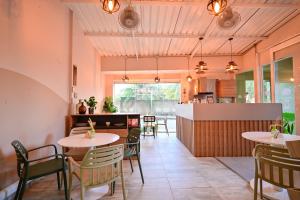 a restaurant with tables and chairs and a kitchen at Hotel SEREMA in Cartagena de Indias