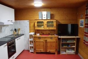 a kitchen with a counter and a tv in a room at Ferienhaus Fernblick in Fraxern +32 photos