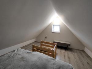 a bedroom with a bed and a chair and a window at Barna kuckó in Mohács