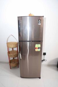 a stainless steel refrigerator with a basket next to it at Mahaweli Haven in Nattarampota