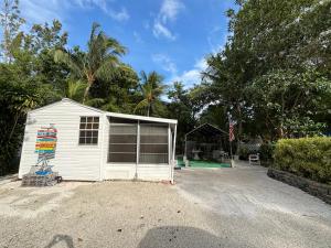 a small white garage in front of a yard at Paradise Found-Key Largo Kampground Divers Welcome in Key Largo
