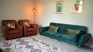 a living room with a green couch and two chairs at Bridge View Cottage in Cawood +21 photos