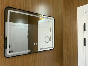 a mirror hanging on a wall with a door at Asolat house in Urganch