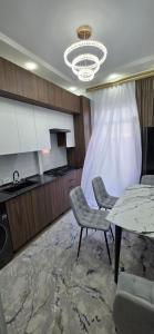 a kitchen with a table and two chairs and a counter at Asolat house in Urganch