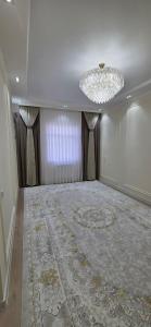 a large room with a chandelier and a large rug at Asolat house in Urganch