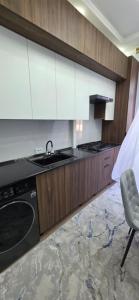 a kitchen with a stove and a sink and a chair at Asolat house in Urganch +7 photos