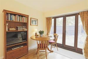 a living room with a dining room table and a tv at 1 Bed in Beccles oc-hfs in Wangford